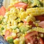 Fresh corn on the cob, tomatoes, avocado, garlic, lime and basil come together in this amazing Summer Corn Salad recipe. It is a MUST have at our dinner table all summer long!